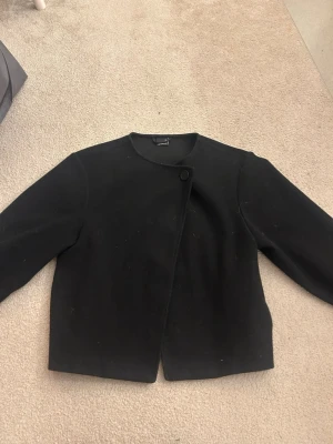 Svart kappa - Super fin svart kappa från Gina, använd sparsamt i ungefär 1 år men i super fint skick! Tvättas såklart innan den skickas om köparen vill de. Storlek XS