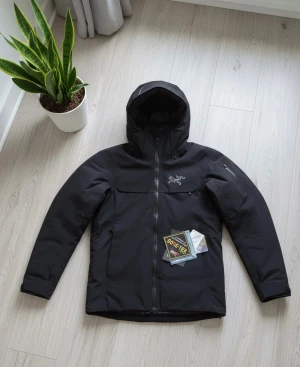 Svart vinterjacka Arc'teryx S - Arc'teryx dunjacka i svart med huva och snyggt broderad logga på bröstet. Jackan är tillverkad i slitstark polyester med GORE-TEX och har dragkedja framtill. Riktigt bra nu till vintern, och även bättre för skidsäsongen 🌧️