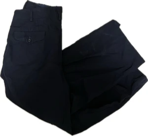 Comme des Garçons Homme byxor - Svarta byxor från Comme des Garçons Hommes som är från 1996, tillverkade i Japan av 100% ull. Klassisk rak passform med knappstängning och ficka med lock bak. Snygga och stilrena, perfekta för dig som gillar minimalistisk design och exklusiva material.