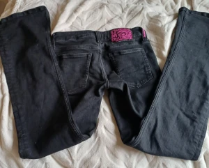 Cheap Monday jeans  - Svarta jeans från Cheap Monday med klassisk femficksdesign och en snygg rosa patch med logga bak i midjan. Storlek 28/30