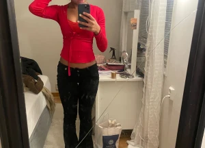 Röd omlottopp med knyt och v-ringning - Tröja från Gina, man kan justera den så att den sitter tight. Pga dåligt material har den gått sönder under som man ser på bild 2 men lika fin ändå.