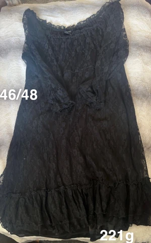 Svart spetsklänning med volang - Svart långärmad klänning i spets från cellbes. Klänningen har vacker spets över hela plagget, volang nertill och en lätt v-ringad hals. Perfekt för dig som gillar romantiska detaljer och en feminin look.🌸 Fint använt skick. Finns någon noppa. Storlek 46/48. 