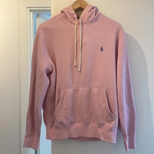 Rosa hoodie från Polo Ralph Lauren - Säljer en rosa hoodie från Polo Ralph Lauren i bomull. Klassisk modell med huva och snören.