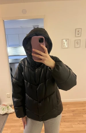 Pufferjacka i läderimitation  - Den är väldigt varm och skön samt har en snygg design.