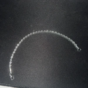 Silverfärgat tvinnat armband - Snyggt armband i silverfärg med tvinnad design. Perfekt accessoar för att lyfta din outfit. Lätt att matcha med andra smycken och har ett smidigt lås.