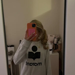 Grå sweatshirt från Isabel Marant - Säljer en grå sweatshirt från Isabel Marant med stort svart logotryck på bröstet. Fint skicka förutom att texten suddats ut lite! Nypris 3200kr!