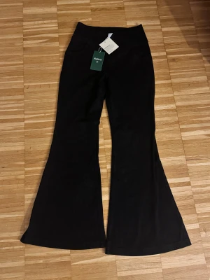 Svarta bootcut byxor från Halara - Snygga svarta bootcut byxor från Halara med hög midja och mjukt, stretchigt material. Byxorna har klassisk siluett med utsvängda ben och diskreta fickor framtill. Perfekta för dig som gillar en trendig och bekväm look. Lite stor i storleken, passar petite S/M