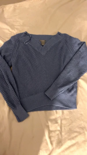 Stickad tröja- blå - Säljer en stickad blå tröja i storlek S, lite off-shoulder för en avslappnad och snygg stil. Bekväm och enkel att matcha med nästan allt i garderoben.