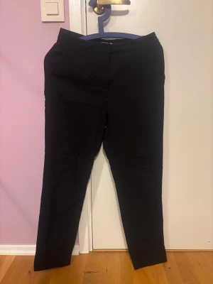Svarta kostymbyxor från hm - Snygga svarta kostymbyxor med smal och rak siluett. Klassisk design med diskreta fickor och midwaist. Perfekta för en stilren look och passar till både skjorta och t-shirt. Materialet är mjukt och har en lätt stretch för extra komfort.