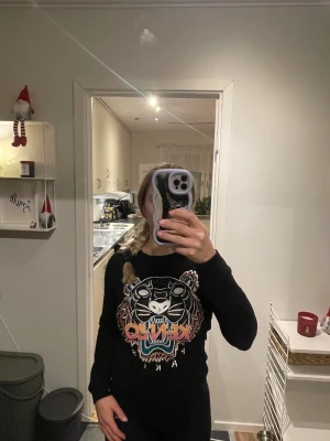 Svart Kenzo sweatshirt med tiger - Svart sweatshirt från Kenzo med ikoniskt broderat tigerhuvud och färgglad Kenzo-logga på bröstet. .