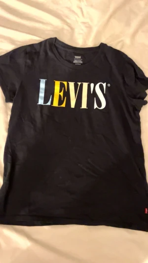 Svart Levi's t-shirt - Svart t-shirt från Levi's i mjuk bomull med Passformen är normal inte för tight och materialet känns skönt mot huden. Perfekt för en chill och stilren look.