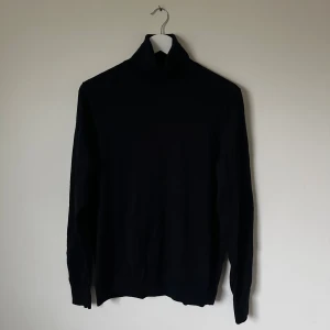 Mörkblå polotröja från Uniqlo - Mörkblå polotröja från Uniqlo i storlek L. Tröjan har lång ärm och klassisk polokrage, perfekt för att hålla värmen. Materialet är mjukt och känns skönt mot huden. Enkel och stilren design som funkar till många olika looks. 5I3