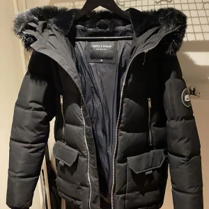 Svart pufferjacka Supply & Demand - Svart pufferjacka från Supply & Demand med stor huva och svart fuskpäls. S men funkar perfekt M.. Perfekt för kalla dagar med sin tjocka vaddering och stilrena look. Speciellt inför vintern❄️