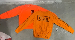 2 Dirty orange sweatshirts med tryck S/XS - Säljer 2 orange sweatshirt från Dirty i storlek small & XS. Tröjorna har svarta tryck med Dirty-logga på bröstet och längs ena ärmen. Rund hals och ribbade muddar. Materialet är mjuk bomull, perfekt för dig som gillar streetwear och vill sticka ut med färg. Kan även säljas styckvis 