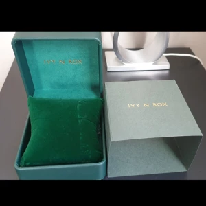 Grön smyckesask från Ivy N Rox - Lyxig grön smyckesask från Ivy N Rox med sammetsliknande innerkudde och elegant guldfärgad logga. Perfekt för att förvara ringar, armband eller halsband. Helt ny!