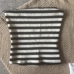 Randig tubtopp från H&M XS - Säljer en ribbad tubtopp från H&M i storlek XS. Toppen har svarta och vita horisontella ränder och är axelbandslös med bandeau-form. Perfekt för dig som gillar en enkel men snygg look. Materialet är mjukt och stretchigt för skön passform.