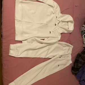 Vita mjukisbyxor från Lacoste, S - Säljer ett par fräscha vita mjukisbyxor från Lacoste i regular fit. Byxorna har resår i midjan och är gjorda i 100% bomull, vilket gör dem riktigt sköna. Perfekta för chill eller träning, med diskret Lacoste-logga på benet.