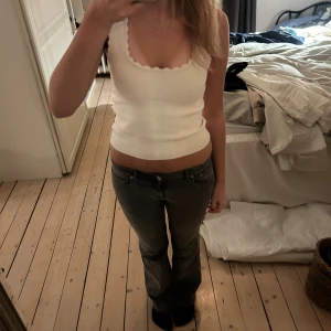 Grå bootcut jeans Low waist  - Säljer ett par gråa jeans med bootcut-modell och klassisk femficksdesign. Jeansen har normal midja och är tillverkade i mjukt denimtyg som ger en avslappnad men snygg look. Perfekta för dig som gillar en tidlös stil med lite extra edge.