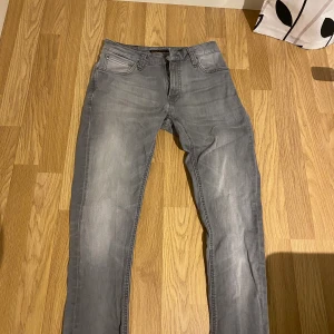 Grå jeans från Nudie Jeansco, 29/34 - Snygga upp sydda grå jeans från Nudie Jeansco i storlek 29/34. Modellen har klassisk femficksdesign, dragkedja och knappstängning. Jeansen är raka i benen och har en cool tvättad look som ger dem extra karaktär. Jeansen är som sagt uppsydda och passar mig perfekt som är 158cm