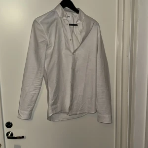 Vit skjorta från Lindbergh White XS - Klassisk vit skjorta från Lindbergh White i slim fit-modell. Skjortan har långa ärmar, knappar framtill och en stilren krage. Tillverkad i bomull med Superflex för extra rörelsefrihet. Perfekt för dig som gillar en clean och enkel look.