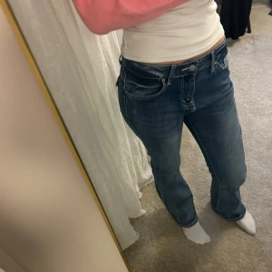 Blå bootcut jeans med låg midja - Snygga blå jeans med bootcut passform och låg midja. Jeansen har en lätt tvättad look och är tillverkade i jeansmaterial.