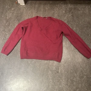 Vinröd v-ringad tröja från Kookai - Snygg vinröd stickad tröja från Kookai med v-ringad hals och långa ärmar. Tröjan har en klassisk passform och är perfekt för dig som gillar stilrena och enkla plagg. Materialet är mjukt och skönt men kan sticks och färgen är djup vinröd som verkligen poppar.❣️