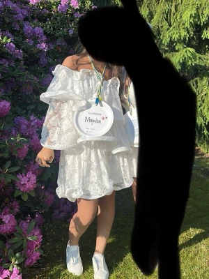 Vit offshoulder spetsklänning - Säljer en superfin vit offshoulder klänning med volangdetaljer och spets. Klänningen är kort och har en luftig passform, perfekt för sommarens alla tillfällen. Matcha med sneakers eller sandaler för en fräsch look. Säljs inte längre kan gå ner i pris vid snabb affär skriv om ni har frågor 