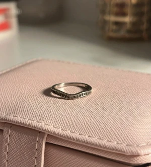 silverfärgad ring med stenar - En stilren och tunn silverfärgad ring med små gnistrande stenar infattade runt hela bandet. Perfekt för dig som gillar minimalistiska smycken med lite extra bling. Passar snyggt att bära ensam eller att stapla med andra ringar.