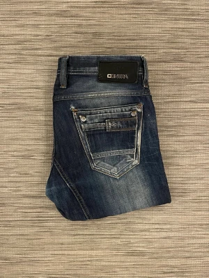 Contra - Sällsynta Jeans - Säljer dessa riktigt snygga jeans från märket Contra. Jeansen är sparsamt använda men har små skavanker som syns på bild. Små slitningar vid backfickan.   Mått: (31) Midjevidd: ~ 42,5 cm Längd: ~ 105 cm Ankelvidd: ~ 19 cm  Hör av dig vid frågor eller funderingar!
