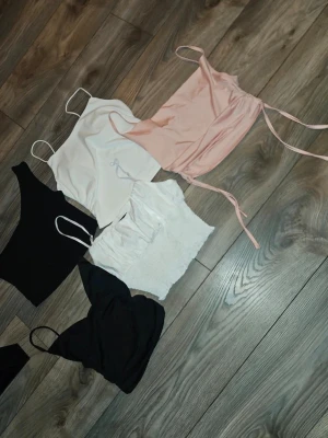 Fem trendiga linnetoppar i olika färger storlek s - Säljer ett paket med fem olika linnetoppar i svart, vitt och ljusrosa. Några har tunna axelband och en topp har snörning i sidan. Perfekta för sommaren och att styla lager på lager. Storlek s 