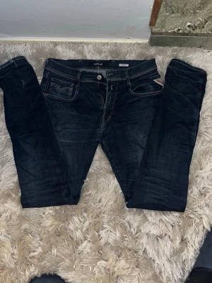 Replay anbass jeans - Snygga mörkblå slim jeans från Replay med klassisk femficksdesign och detaljerade bakfickor. Jeansen har låg midja och är tillverkade i stretchigt denim för en bekväm passform. Perfekta till en avslappnad streetstyle-look.
