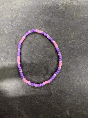 Lila och rosa pärlarmband Storlek M  - Ett handgjort armband med små pärlor i lila och rosa nyanser. 