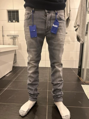 Grå skinny jeans från Jacob cohen - Säljer ett par grå skinny jeans från Jacob cohen med snygga slitningar och klassisk femficksdesign. Jeansen har blå detaljer vid fickorna och är tillverkade i stretchigt bomullsmaterial för en bekväm passform. Helt nya modell : bard. Og tillkommer och pris kan diskuteras 