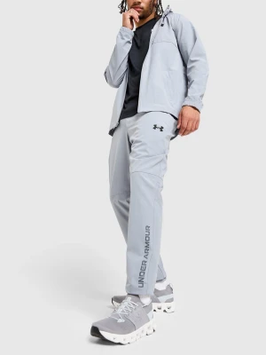 Ljusgrå exclusiv träningsset från Under Armour - Snyggt ljusgrått träningsset från Under Armour med jacka och byxor. Setet har dragkedja på jackan, logga på bröstet och benet samt texten UNDER ARMOUR längs benet.  Tröjan är storlek S och byxorna är storlek M. Helt ny använd Max 5 gånger!