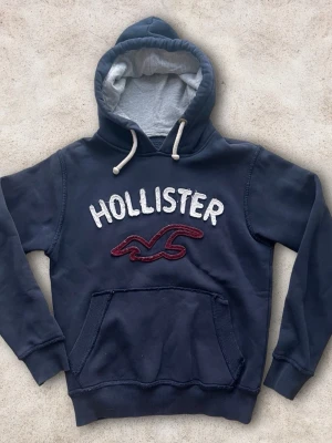 Hollister hoodie S - En fet hoodie från hollister i storlek S även fast det stå M. Mycket bra skick! Färg mörkblå med rött tryck. 😀