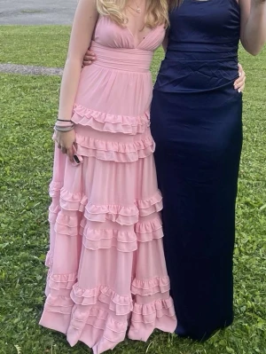 Lång rosa volangklänning/ balklänning  - Romantisk långklänning i ljusrosa med flera lager volanger och djup v-ringning. Klänningen har smala axelband och markerad midja för en feminin siluett. Perfekt till bal eller fin middag. Endas använd 1 gång! Skriv för mer information och fler bilder!❤️