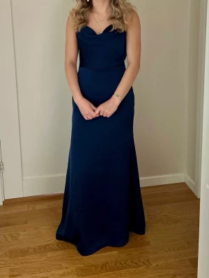 Mörkblå balklänning - Säljer denna vackra mörkblå balklänningen med öppen rygg. Den går hela vägen till golvet för mig som är 169 cm lång. Jag hade den på 9:ans bal så är använd endast en gång. Jag köpte den för 1400 kr. 