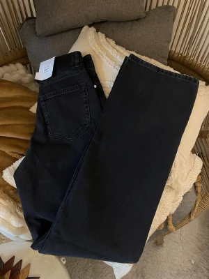 Svarta Never Denim ”Regular Wide” Nya! 26/32) - Säljer ett par superfina svarta jeans från Never Denim (BikBok) i modellen Regular Wide. De är endast provade och lappen sitter kvar, så de är i absolut nyskick! 🌟 Modellen är perfekt för dig som letar efter den trendiga siluetten: • Passform: High Waist (hög midja) med Straight Leg/Wide Leg-look. • Färg: Snyggt svart  • Storlek: Waist 26, Length 32. • Detaljer: Rejäl denimkvalitet som ger en snygg form. Passar perfekt till både sneakers och klackar. 