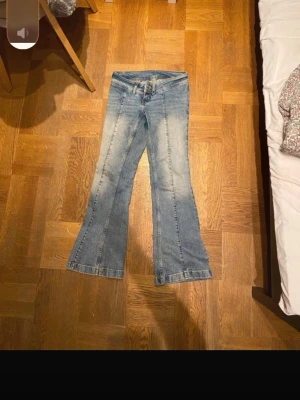 Ljusblå bootcut jeans - Säljer ett par ljusblå bootcut jeans med slitningar och utsvängda ben. Klassisk femficksmodell och normal midja. Perfekta för en avslappnad och trendig look. Materialet är denim i bomull.pris kan diskuteras 