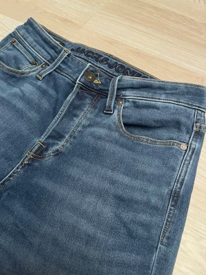 Blå jeans från Jack & Jones - Snygga blå jeans från Jack & Jones med klassisk femficksmodell. Tillverkade i slitstarkt denimtyg som ger en tidlös look. Perfekta för dig som gillar enkel och stilren design storleken är 29 30 