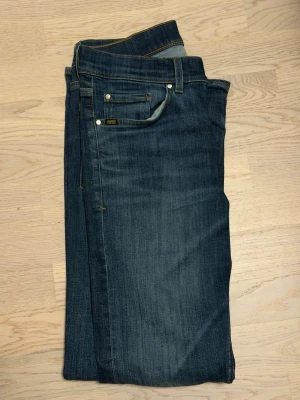 Tiger of Sweden Evolve - Snygga blå jeans från Tiger of Sweden, modellen heter Evolve och storlek 30/32. Modellen har slim passform och är flexibel liknande replay hyperstretch, tillverkad i slitstarkt denim med subtil tvättad effekt. Perfekt för dig som gillar slim jeans som har flexibilitet.