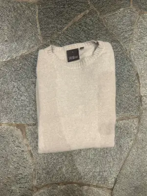 Snygg beige rundhalsad tröja från Oscar Jacobson i lyxig kashmir och ull blandning. Tröjan har ribbade muddar vid ärmslut och nederkant samt klassisk passform. Perfekt för dig som gillar stilrena och mjuka plagg. Nypris: 1499. Notera att jag har råkat tvätta den i för hög grad vilket har krympt den. Därför är tröjan i storlek S-M 