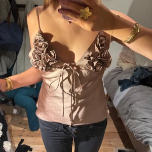 Champagnefärgad satinlinnetopp med volang - Supersnygg champagnefärgad linnetopp i satin med så nice detaljer, har en pytteliten fläck på men inget man tänker på allls( kan skicka bild) 