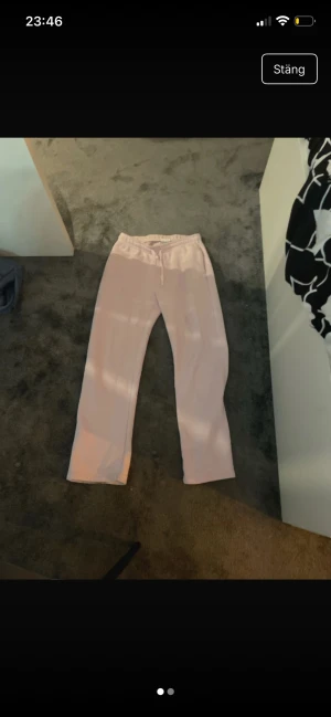 Ljusrosa mjukisbyxor från Gina Tricot - Säljer ett par ljusrosa mjukisbyxor från Gina Tricot, basically basics-kollektionen. Byxorna har rak passform, resår i midjan och snörning för extra komfort. Mjukt material som är perfekt för chill dagar hemma. Dom är lite slitna vid botten men det syns verkligen ingenting. Dom är också lite smutsiga men borde gå bort med en tvätt! Skriv för mer bilder. Pris kan diskuteras.