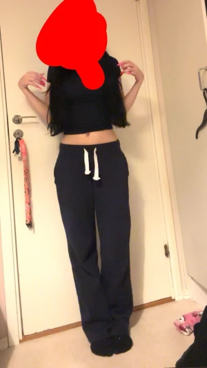 Russemerch Mörkblå mjukisbyxor med snörning XS - Säljer ett par mörkblå mjukisbyxor från Russemerch i storlek XS. Byxorna har vit snörning i midjan och är tillverkade i mjukt bomullsmaterial. De har en relaxed passform och raka ben, perfekta för chill dagar hemma eller när du vill vara bekväm.