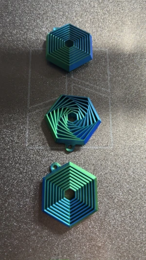 1st 3D-Printad Hexagon fidget nyckelring - En väldigt unik nyckelring i en hexagon form. Den är gjord av 2 färger grön och blå Fidgeten är tillverkad för att avlasta stress samt ha med vid dina nycklar 🔑  Perfekt julklapp till någon som behöver något att trassla med!