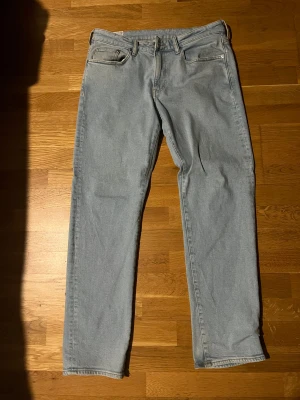 Ljusblå regular fit jeans från H&M - Säljer ett par ljusblå jeans från H&M i regular fit. Klassisk femficksmodell med raka ben och normal passform. Jeansen är tillverkade i bomull och har en enkel, stilren look som funkar till det mesta. Perfekt för dig som gillar avslappnad stil.