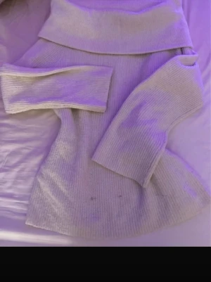 Vit ribbad offscholder från H&M - Säljer en vit polotröja från H&M i storlek S. Tröjan är ribbstickad med lång ärm och har en bred polokrage som ger en chill vibe. Perfekt för lager-på-lager och passar till jeans eller kjol. Materialet är mjukt och känns skönt mot huden.