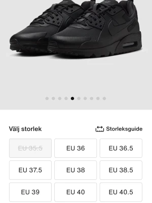 Svarta Nike Air Max sneakers - Säljer ett par helsvarta Nike Air Max sneakers med snygg, sportig design och synlig Air-dämpning i sulan. Skorna har snörning, rund tå och är tillverkade i syntet och skinn för en cool look. Perfekta för dig som gillar streetstyle och komfort.