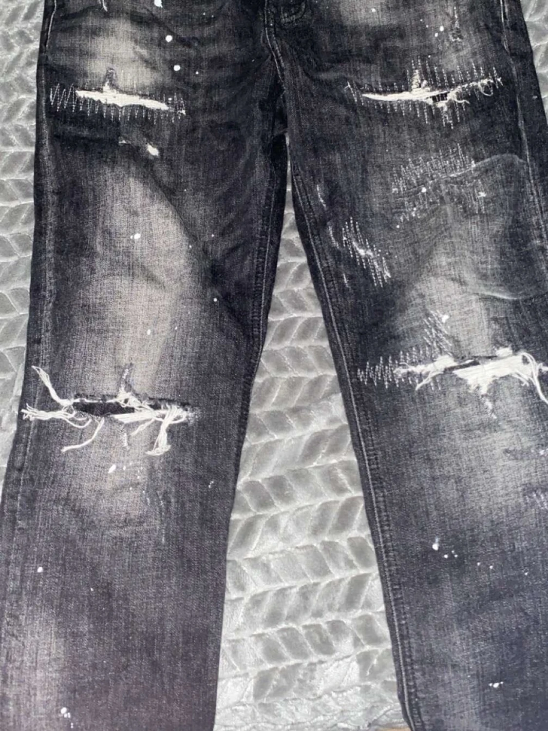 Svarta slitna jeans med färgstänk